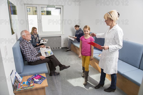 Receptionist calling for the next patient in the waiting room of a dental office