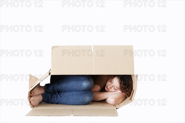 Young woman sleeping in a removal box