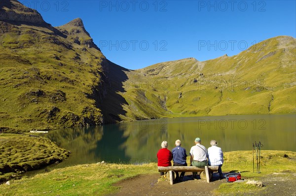 Walkers having a rest next to Bachalpsee lake near Grindelwald First