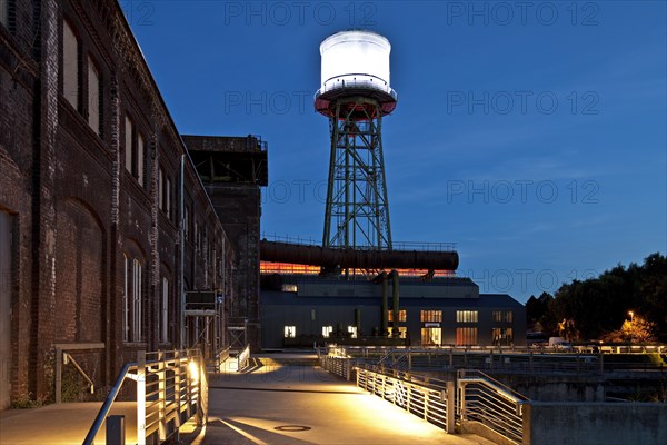 Jahrhunderthalle or Centennial Hall with a water tower at dusk