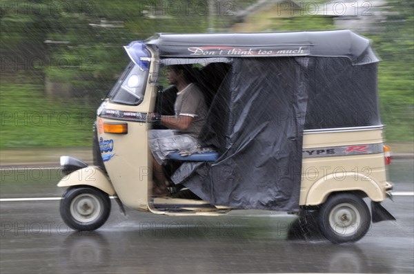 Three-wheeler in heavy rain