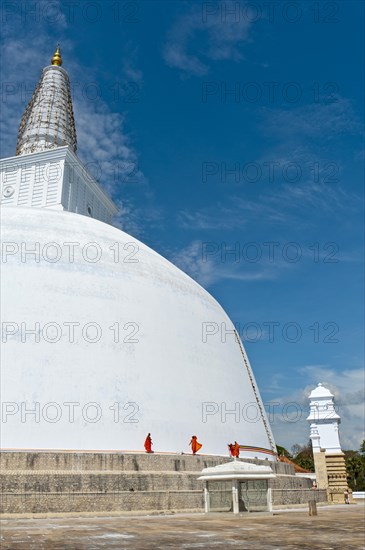 Monks at a large white stupa