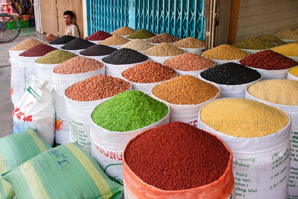 Market vendor offering various sorts of beans