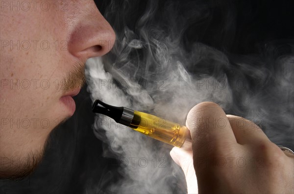 Man smoking an electronic cigarette and exhaling vapour