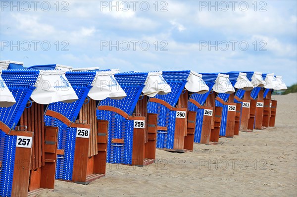 Roofed wicker beach chairs on the beach