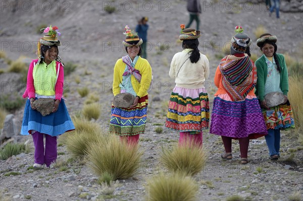 Young women carrying heavy stones to secure the shores of an artificial lake for irrigation