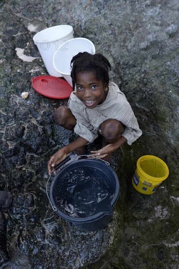 Girl fetching water at a spring