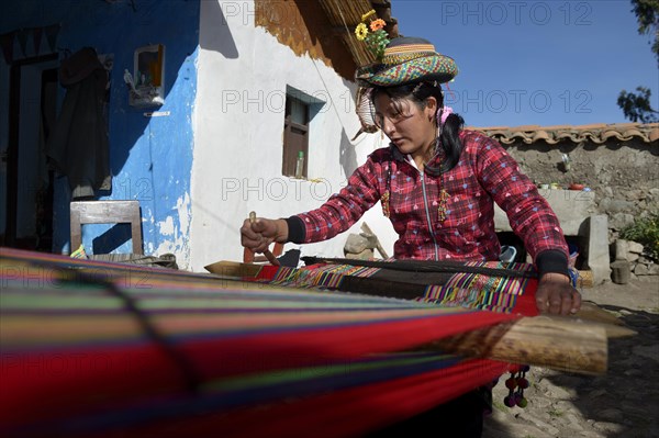 Young woman weaving traditional cloth at the loom