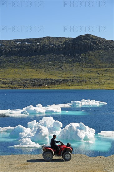 Man of the Inuit people riding a quad bike