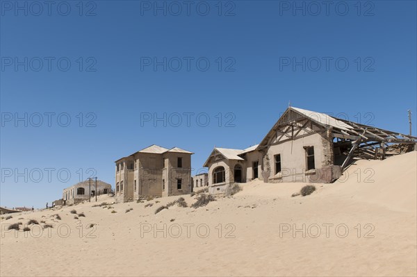 Houses of a former diamond miners settlement that is slowly covered by the sand of the Namib Desert