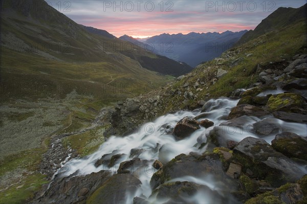 A mountain stream waterfall at sunrise