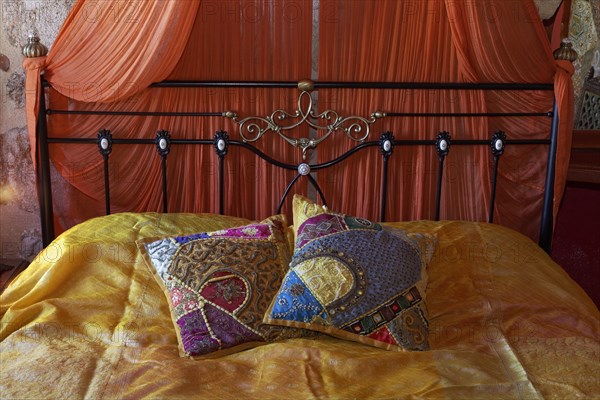 Romantic metal bed with canopy and two oriental silk cushions