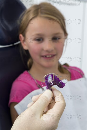 Dentist showing braces to a girl
