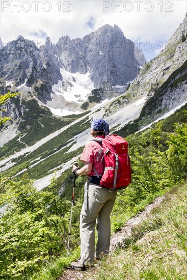 Female hiker looking towards the Wilder Kaiser Mountains from the Wilder-Kaiser-Steig hiking trail