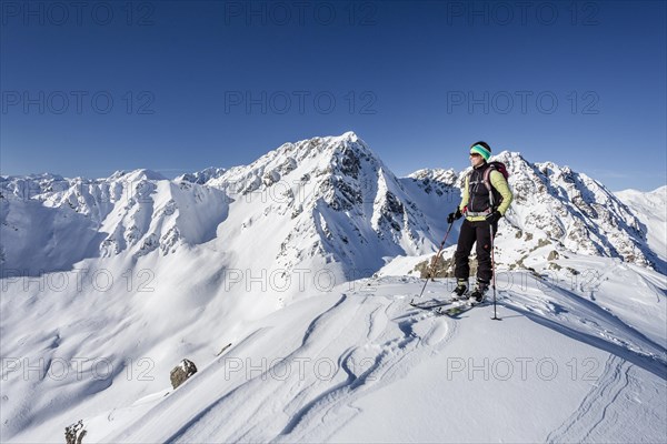 Ski tourer standing on the summit of Seespitz mountain