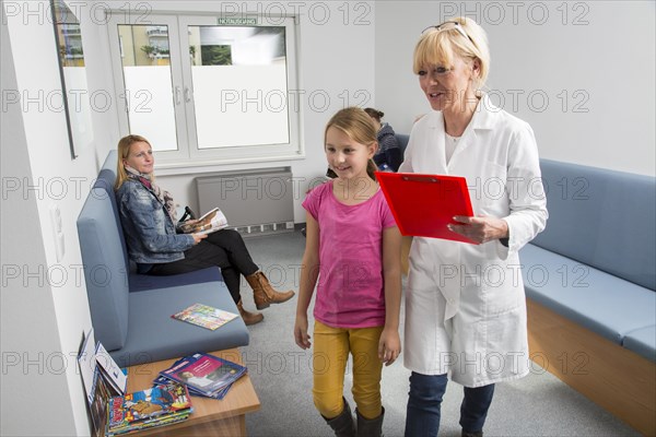 Receptionist with a patient in the waiting room of a dental office