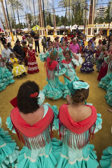 Women wearing gypsy dresses perform traditional Andalusian dances at the Feria del Caballo