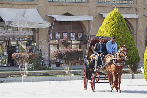 Iranians riding in a horse-drawn carriage