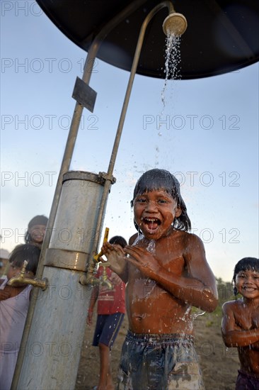 Boy of the Xavantes people taking a shower at a waterhole