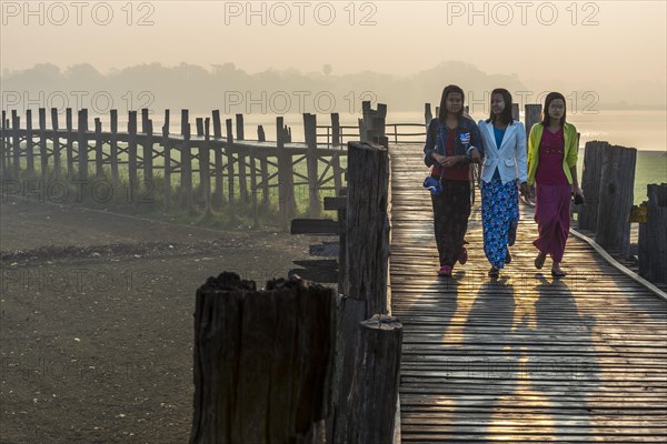 Girls with tanaka on their faces on a teak bridge