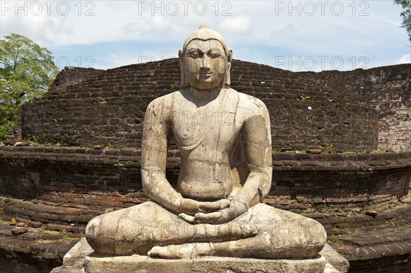 Seated Buddha statue made of stone in a meditation posture