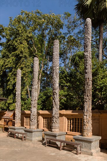 Decorated wooden pillars in the courtyard of Wat Doi Ngam Muang