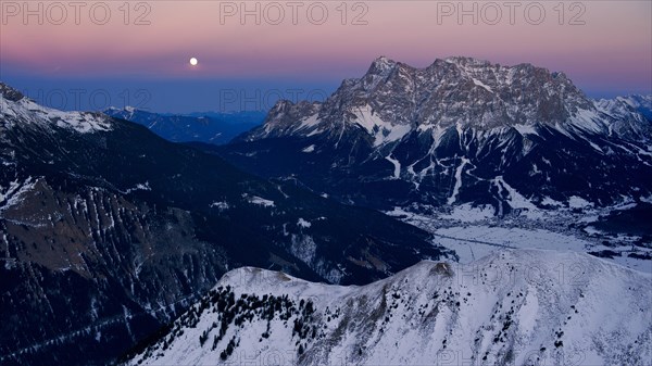 Summit of Mt Zugspitze with a full moon at dusk