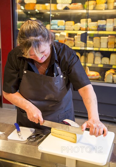 Saleswoman at the cheese counter in the supermarket