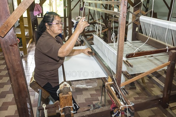 Thai woman weaving silk