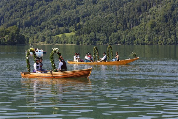 Locals wearing traditional costumes in decorated wooden Platte boats