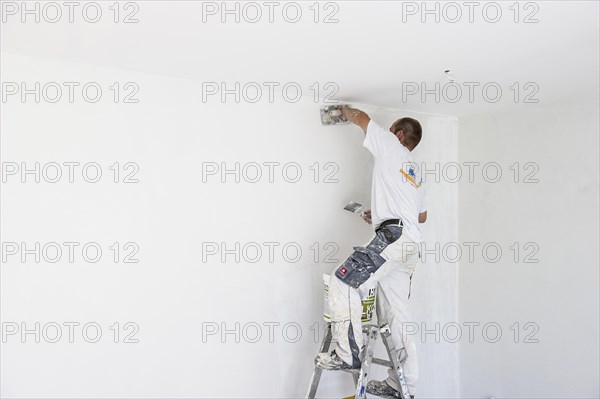 Craftsman plastering the wall of a flat