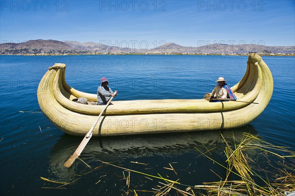 Two local in a traditional rowing boat of Totora reed on Lake Titicaca