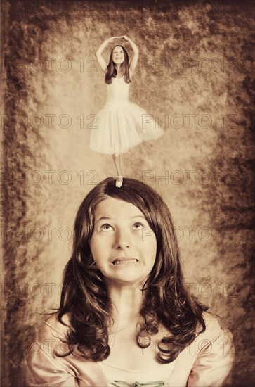 Little ballerina dancing on the head of a girl