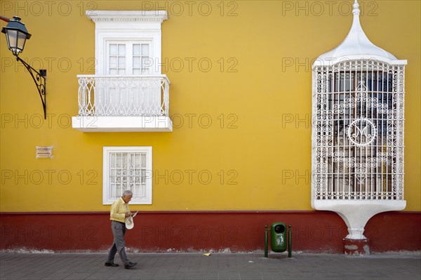 Old man walking in front of Casa de la Emancipacion