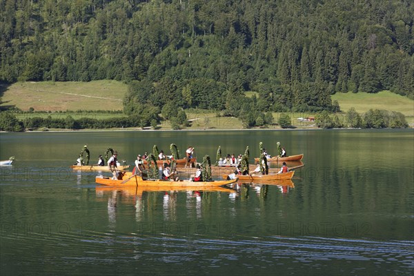 Locals wearing traditional costumes in decorated wooden Platte boats