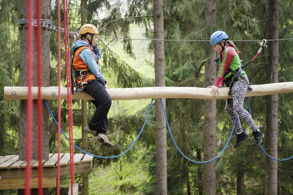 Roped up girls climbing in a climbing park