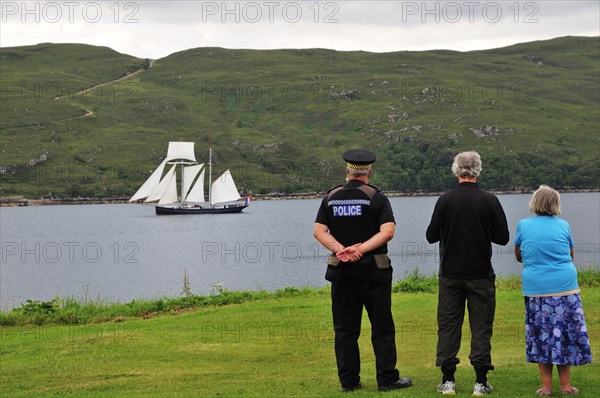 People on the shore looking at the Dutch two-masted Topschoner Wylde Swan on Loch Broom