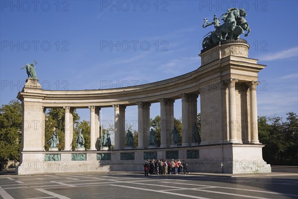 Tourist group standing in front of the colonnade on Hero's Square or Hosok tere