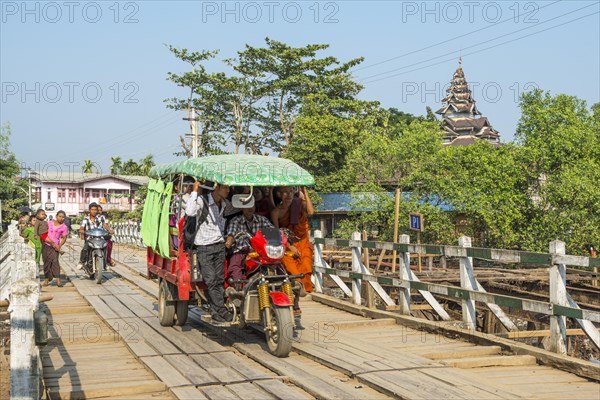 Three-wheeled tuk tuk on a bridge