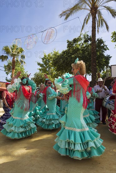 Women wearing gypsy dresses perform traditional Andalusian dances at the Feria del Caballo