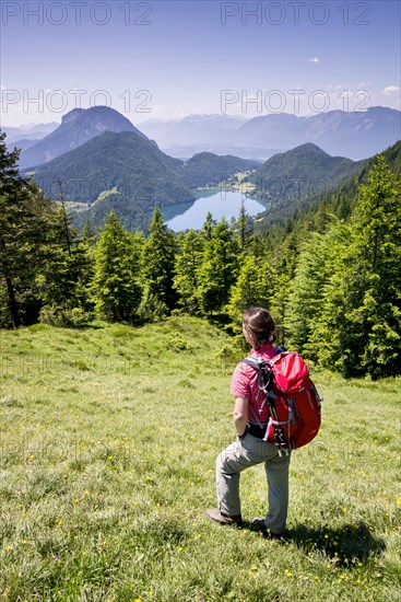 Female hiker observing the view from the Wilder-Kaiser-Steig hiking trail towards Hintersteiner Lake