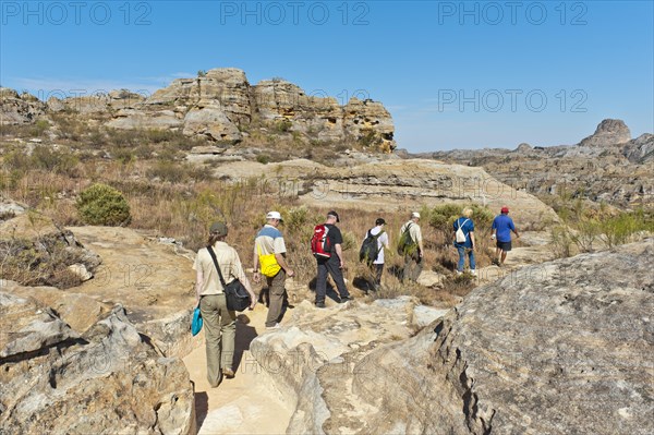 Hikers on trail through rocky landscape