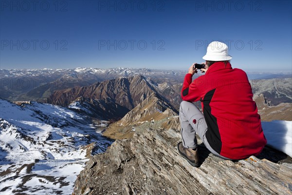 Mountain climber on the summit of Wilde Kreuzspitze Mountain with views over the Pfunderer Mountains towards the Wipptal valley