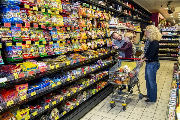 Family shopping in the candy section of a supermarket