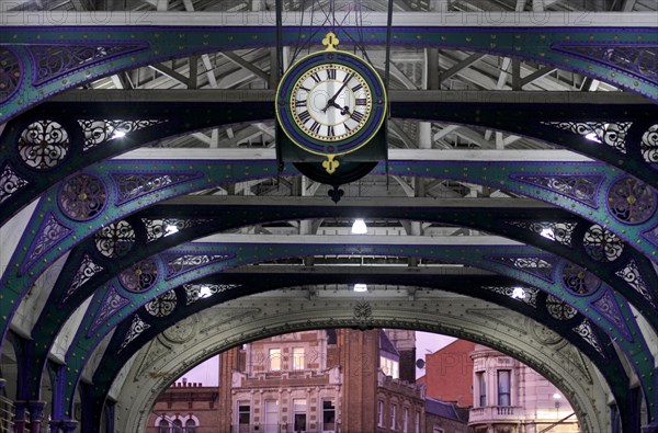 Clock and wrought iron ornaments at dusk