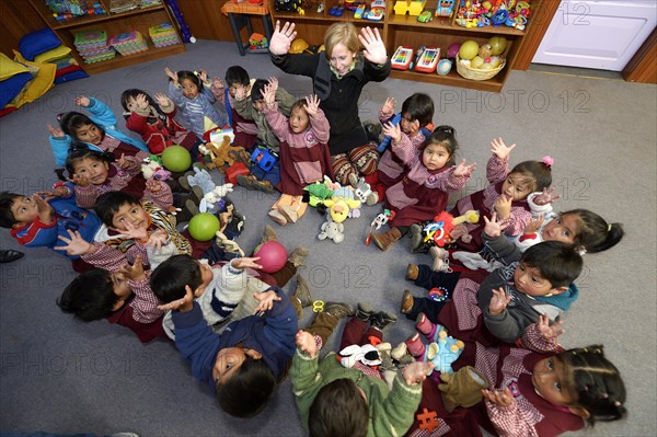 Children sitting on the floor in a circle in a kindergarten
