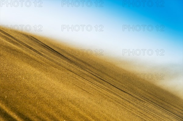 Sand blowing in a storm over the crest of a dune