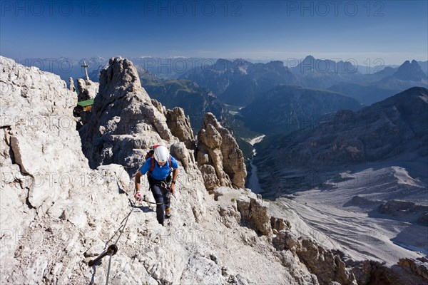 Mountain climber ascending the Via Ferrata Marino Bianchi climbing route on Cristallo di Mezzo Mountain