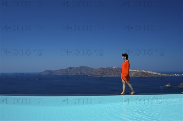Woman walking along the edge of the pool at the Perivolas Hotel