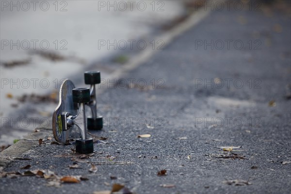 Skateboard lying on a wet street
